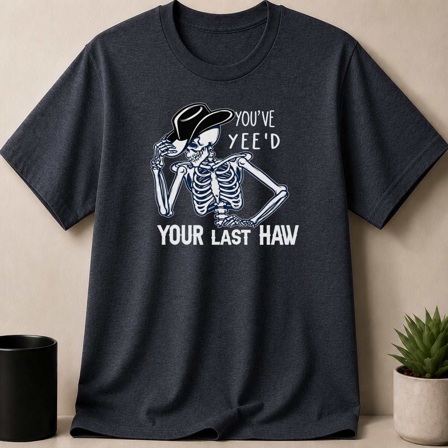 Dark Heather t-shirt — Skeleton in cowboy hat with text "YOU'VE YEE'D YOUR LAST HAW".