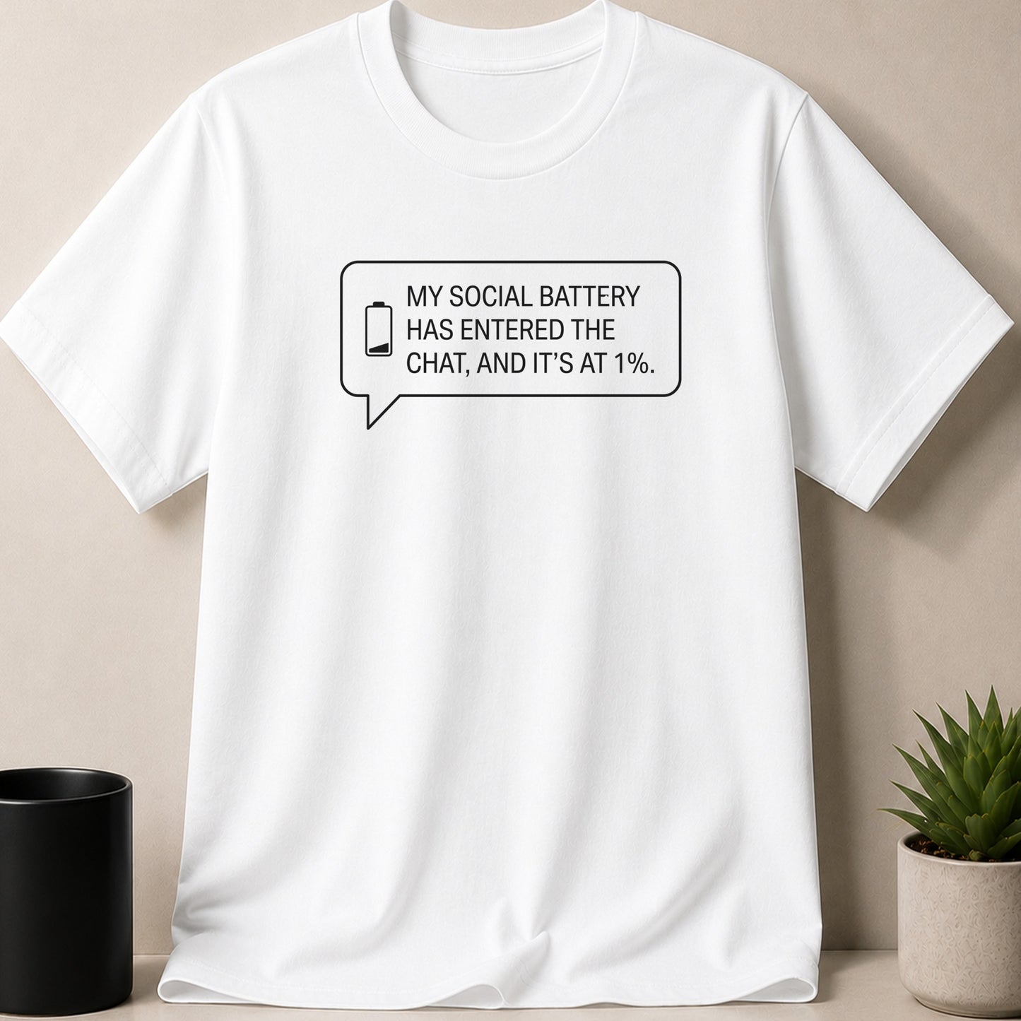 White t-shirt with black text in a speech bubble: "My social battery has entered the chat, and it's at 1%."