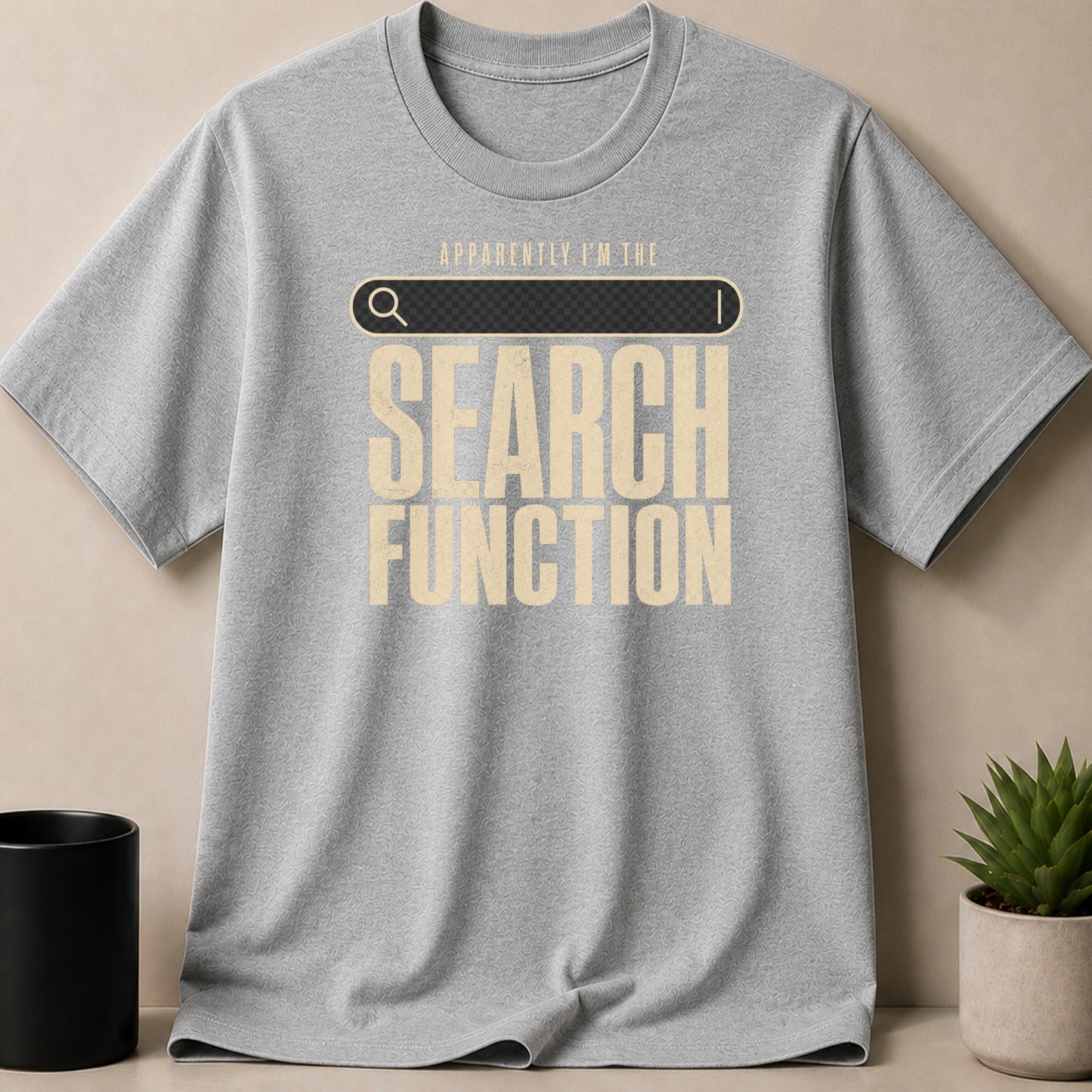 Grey t-shirt with search bar graphic and text "APPARENTLY I'M THE SEARCH FUNCTION".
