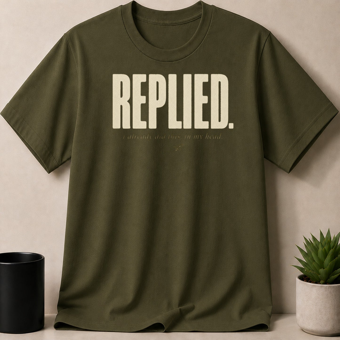 Olive green t-shirt with large text "REPLIED." and smaller text "I already did this in my head."