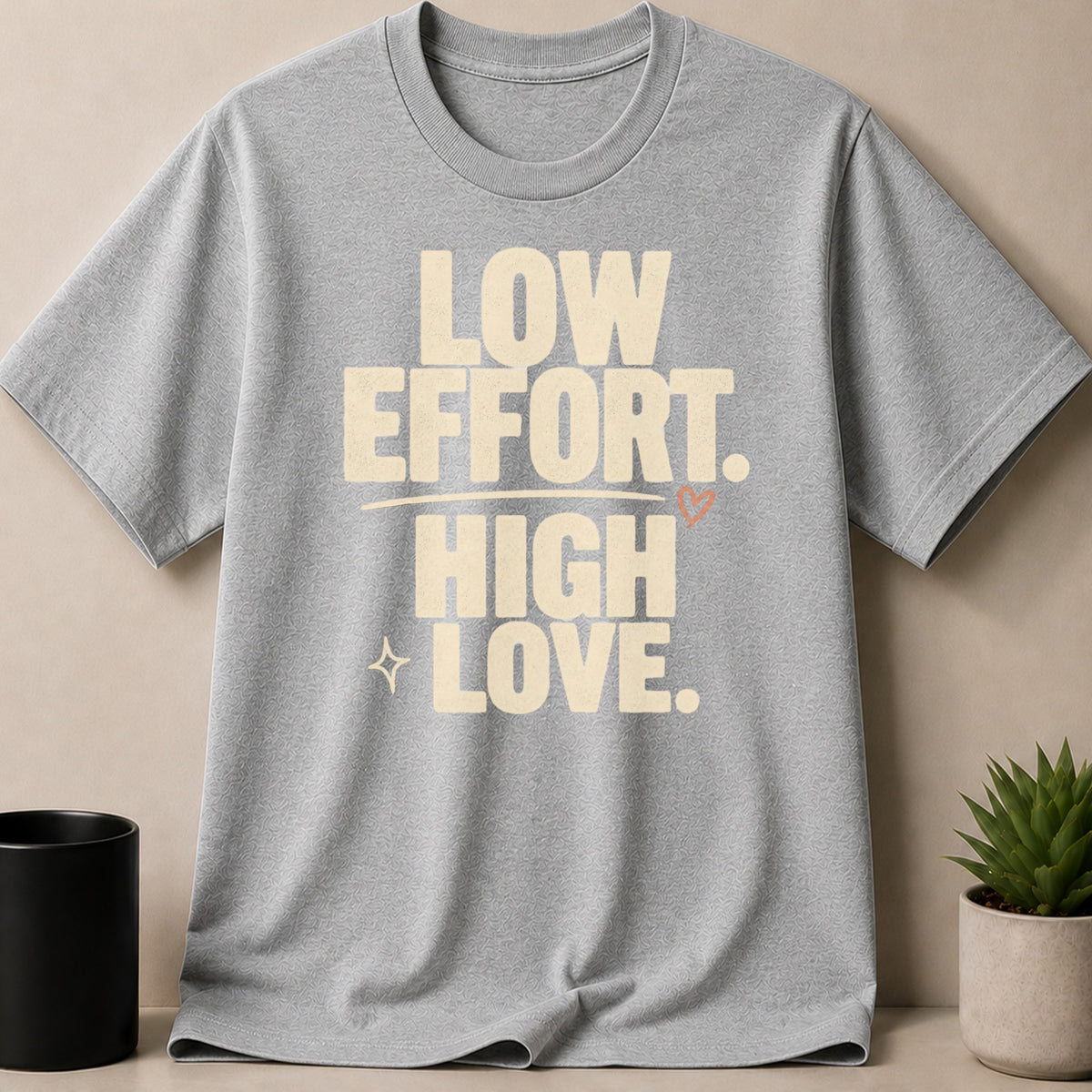 Grey t-shirt with "Low Effort. High Love." text and a small heart.