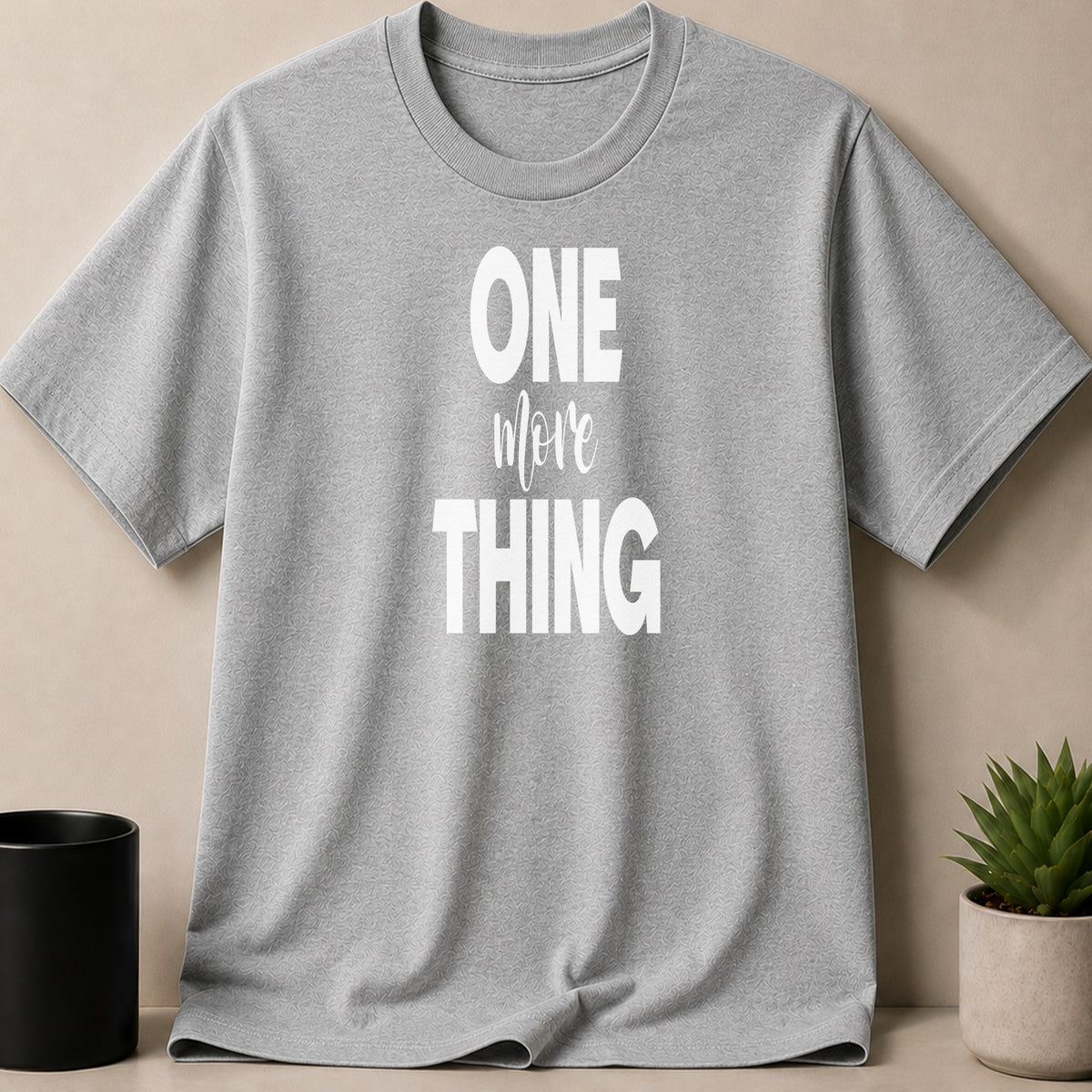 Grey t-shirt with white text "ONE more THING" printed on the front.