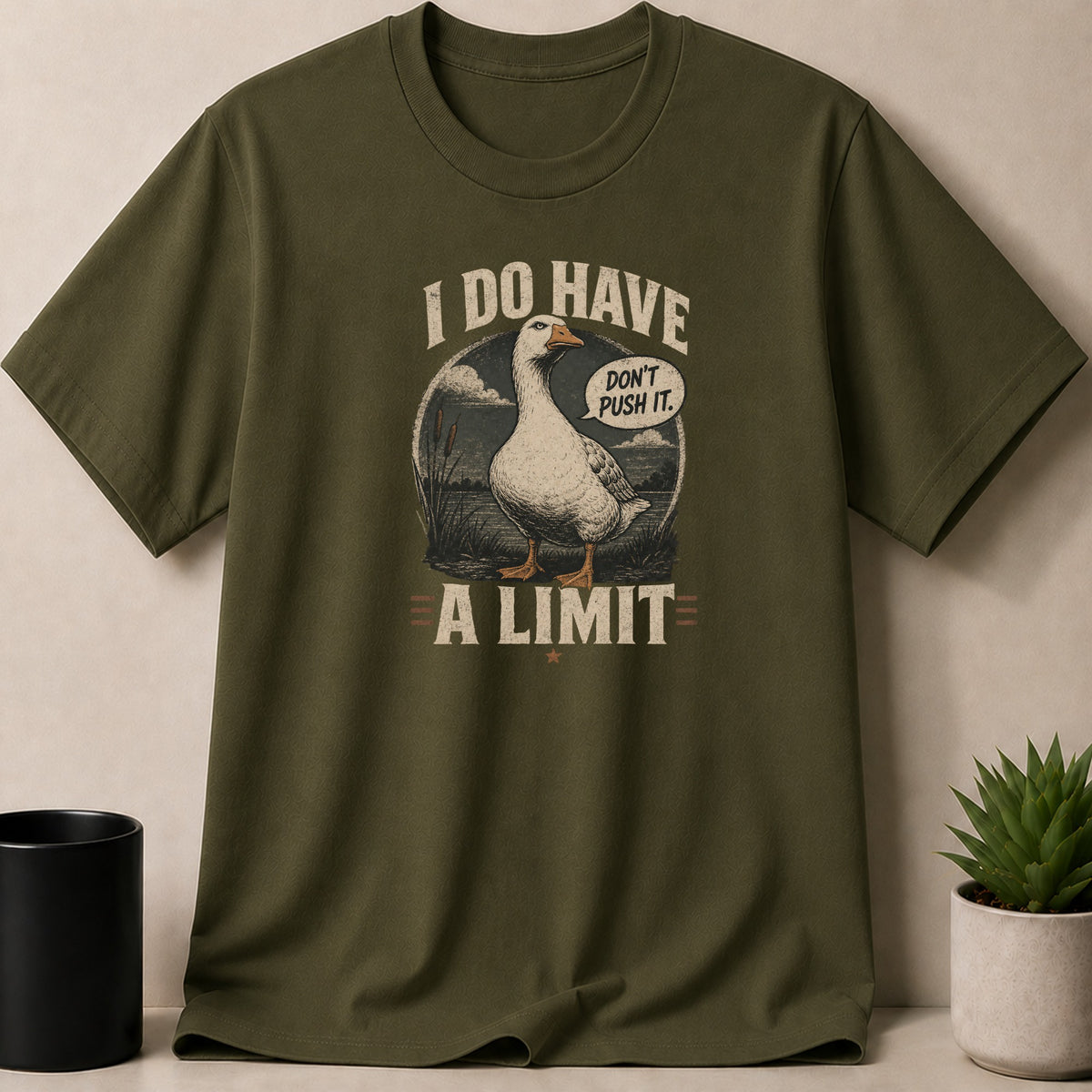Olive green t-shirt with a goose graphic saying "I DO HAVE A LIMIT DON'T PUSH IT."