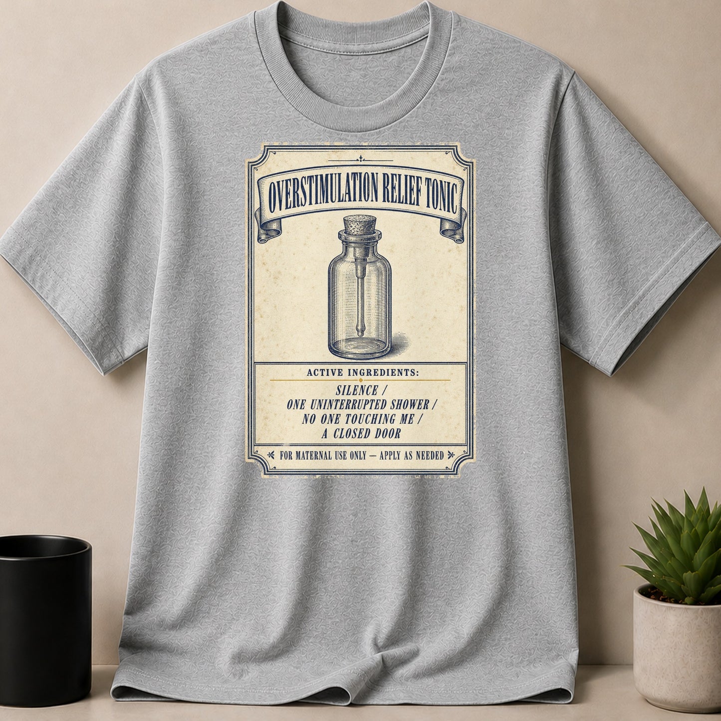 Gray t-shirt with "Overstimulation Relief Tonic" label design and ingredients.
