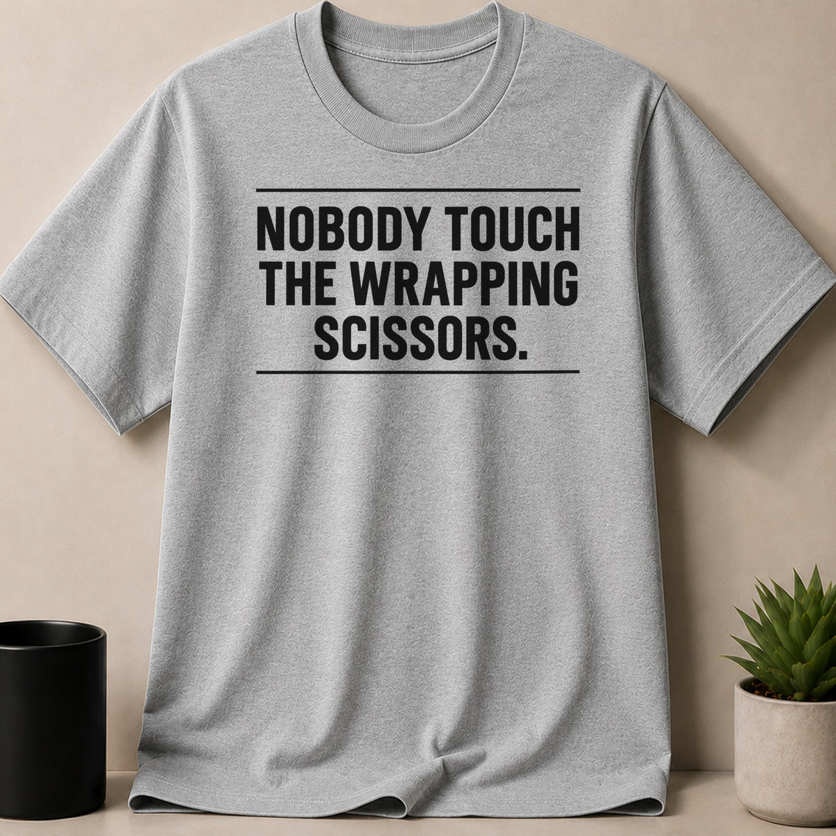 A grey crewneck t-shirt with black text that reads NOBODY TOUCH THE WRAPPING SCISSORS.