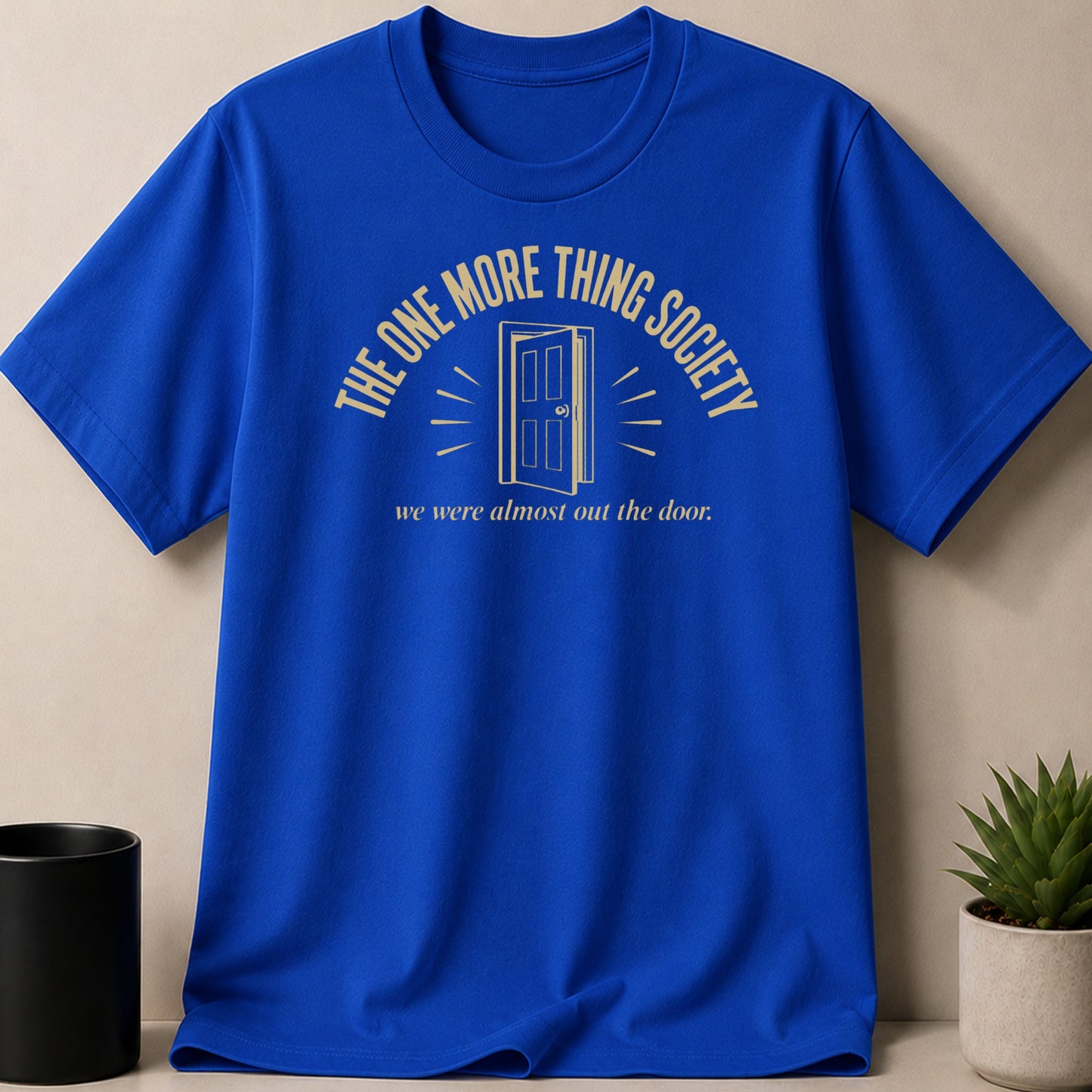 Blue t-shirt with gold text and a graphic of an open door.