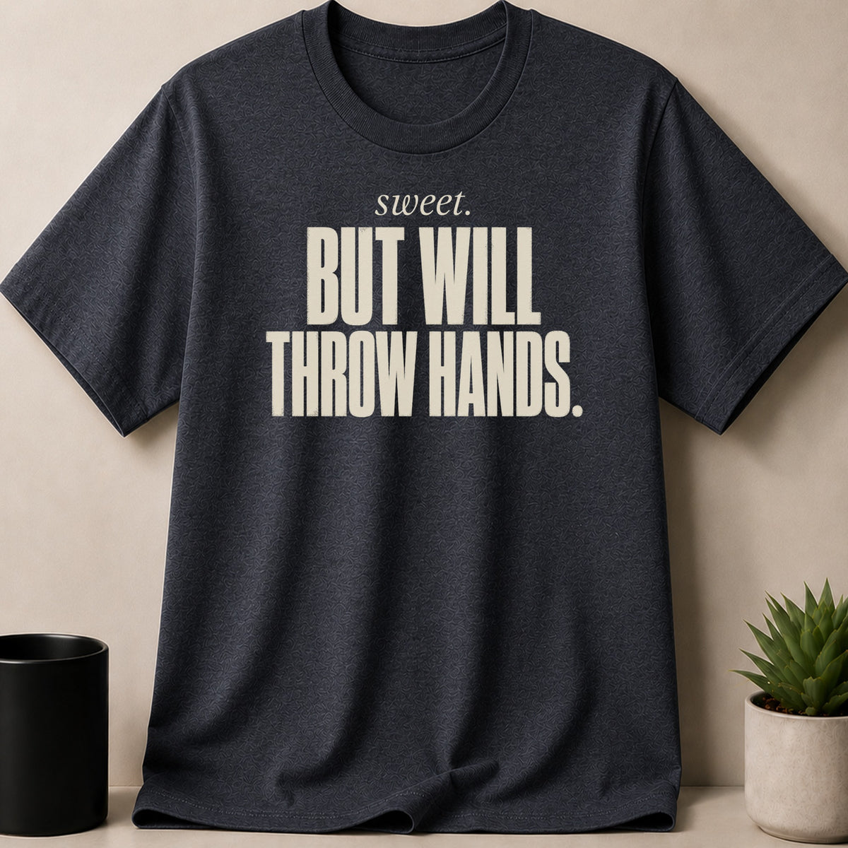 Dark grey t-shirt with "sweet. BUT WILL THROW HANDS." text in beige.