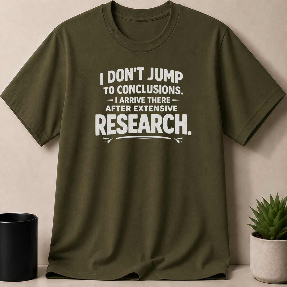 Olive green t-shirt with white text: "I DON'T JUMP TO CONCLUSIONS. I ARRIVE THERE AFTER EXTENSIVE RESEARCH."