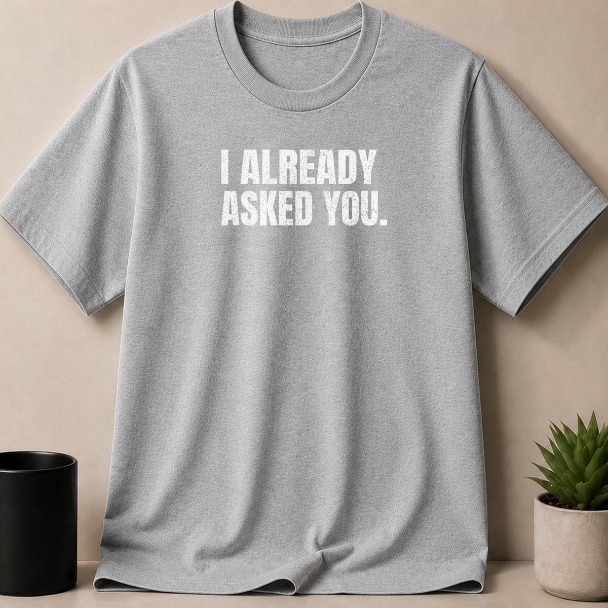 Grey t-shirt with white text that reads "I ALREADY ASKED YOU."