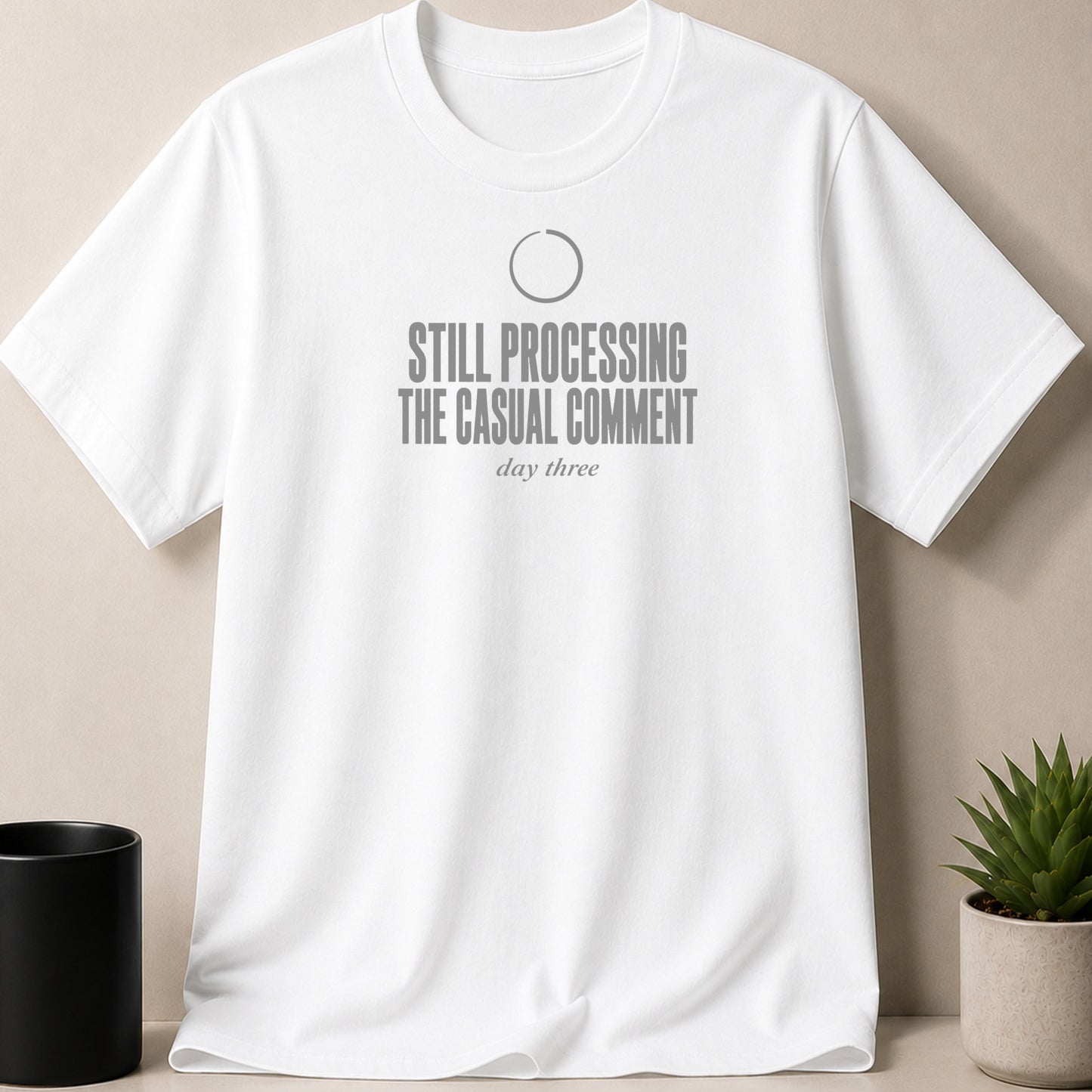 White t-shirt with grey text reading "STILL PROCESSING THE CASUAL COMMENT day three".