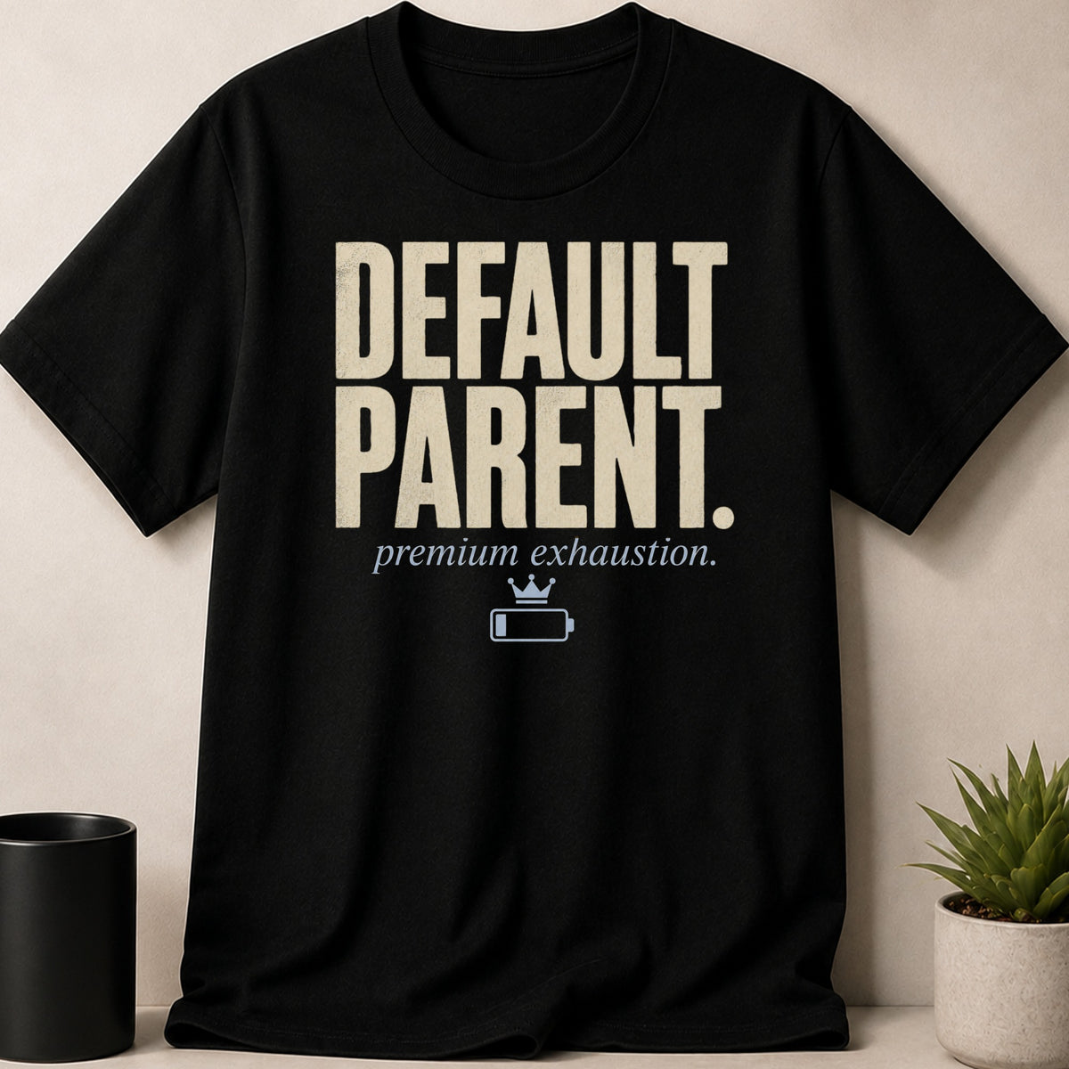 Black t-shirt with "DEFAULT PARENT. premium exhaustion." text and battery graphic.