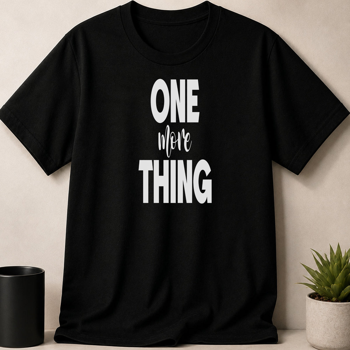 Black t-shirt with white text that reads "ONE more THING".
