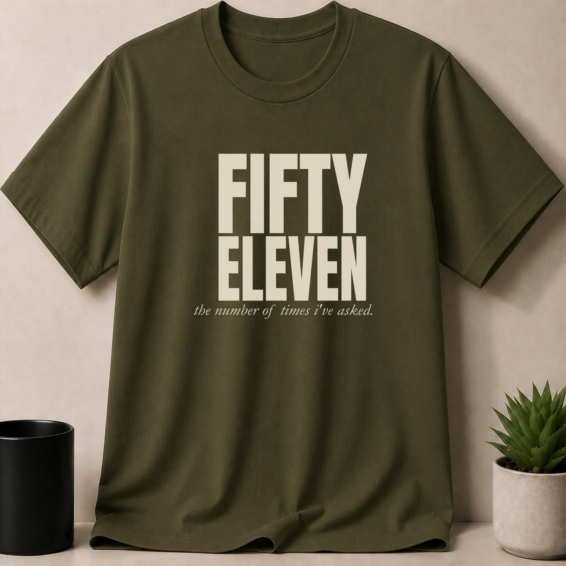 Olive green t-shirt with "FIFTY ELEVEN the number of times I've asked." text.