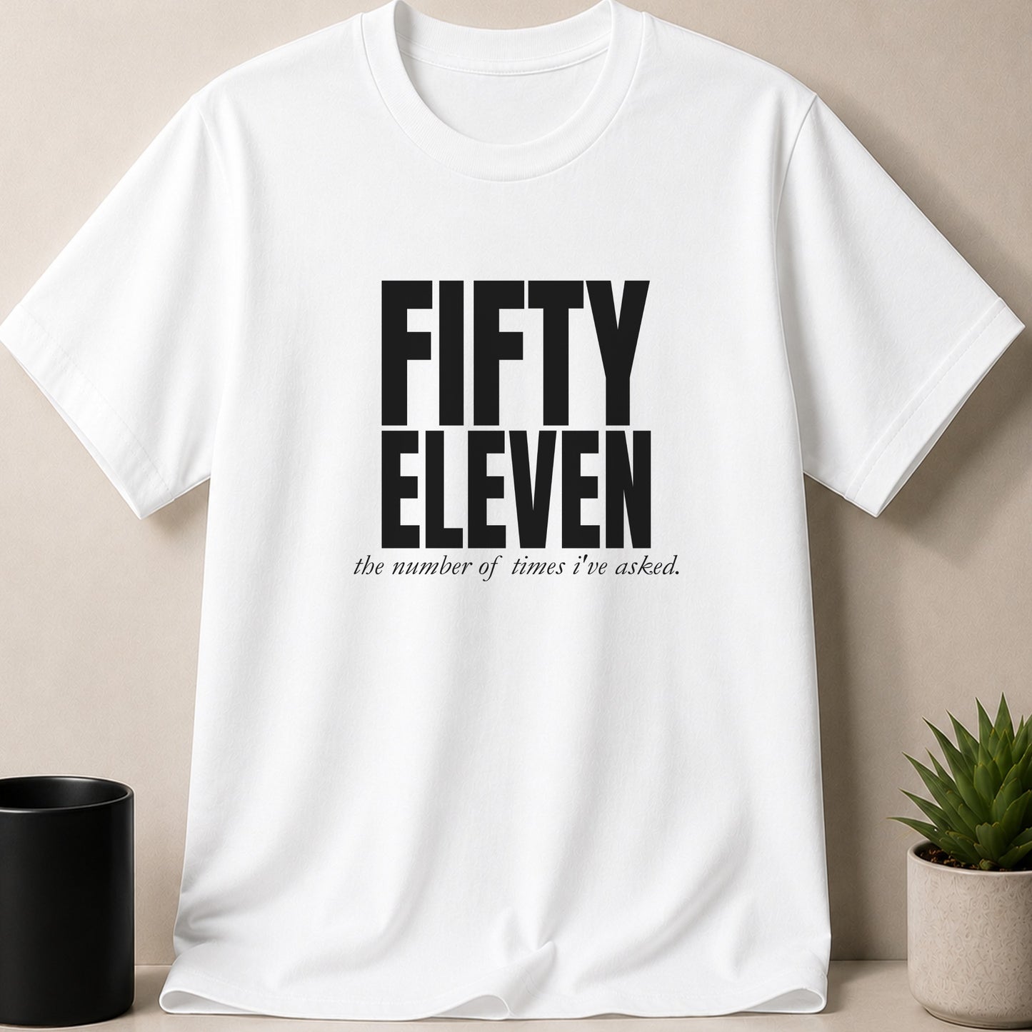 White t-shirt with bold "FIFTY ELEVEN" text and smaller script "the number of times I've asked."