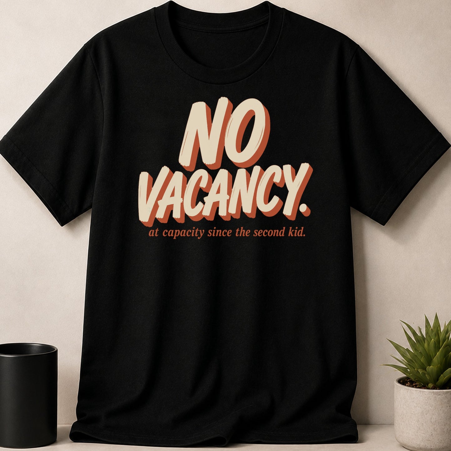 Black t-shirt with "NO VACANCY. at capacity since the second kid." text.