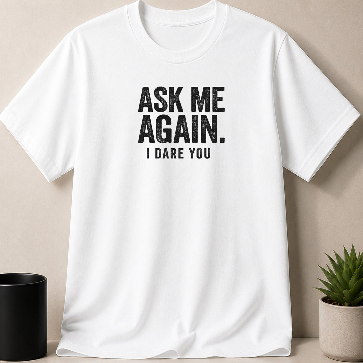 White t-shirt with black distressed text "ASK ME AGAIN. I DARE YOU."