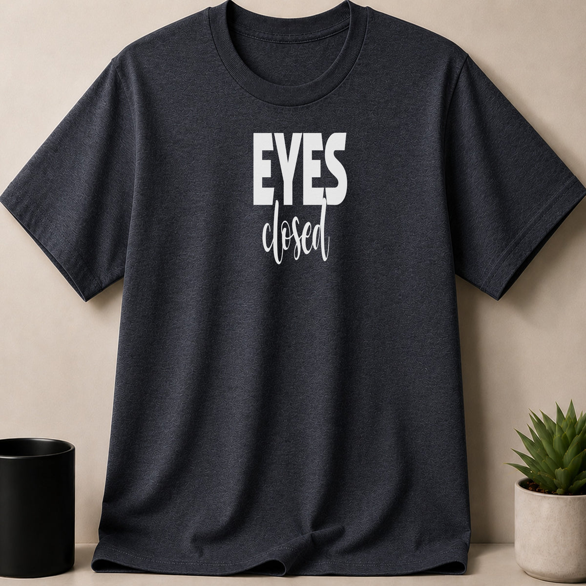 Dark grey t-shirt with white text reading "EYES closed"
