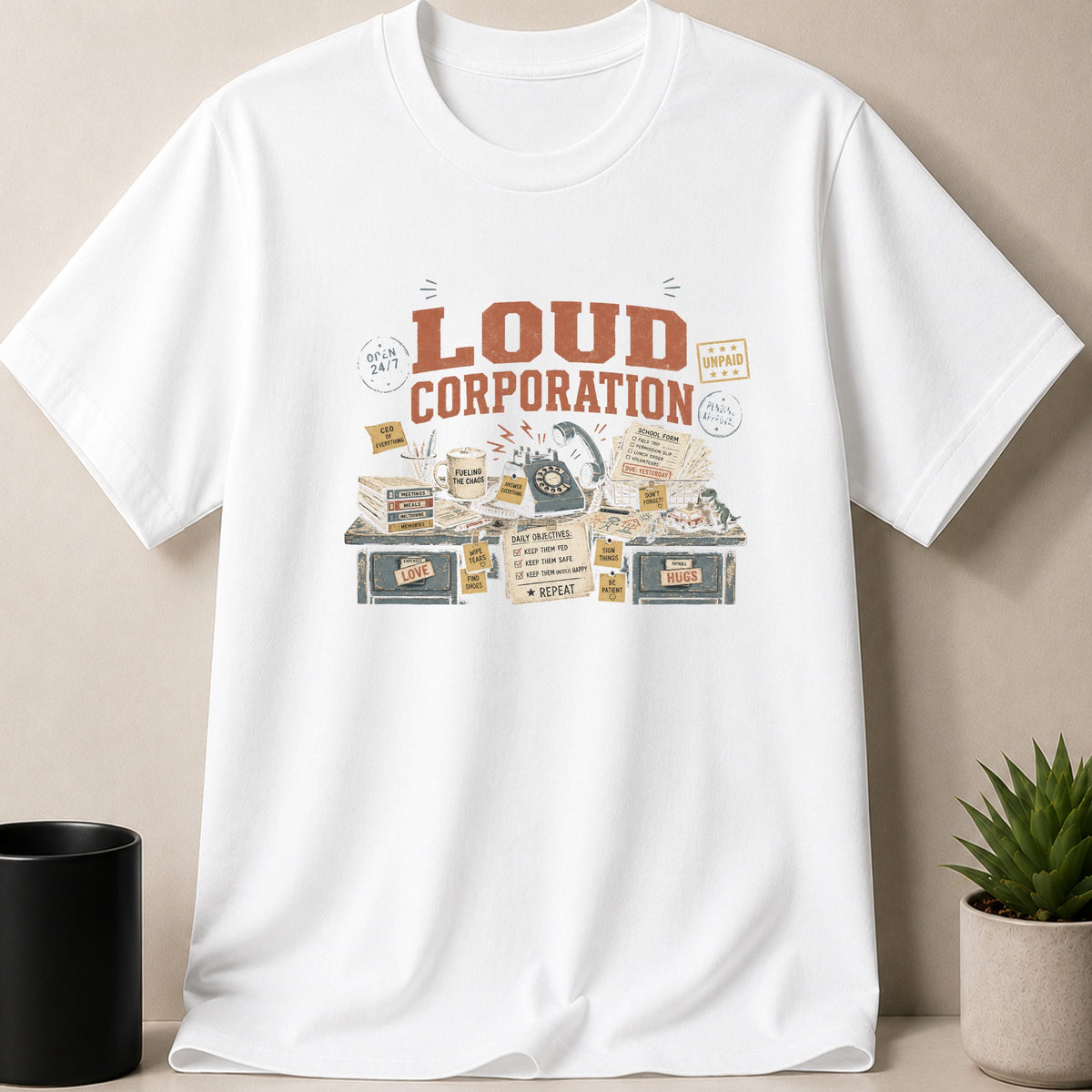 White t-shirt with "LOUD CORPORATION" print featuring office desk items.