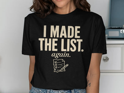 Black t-shirt with cream text "I MADE THE LIST. again." and a checklist graphic.