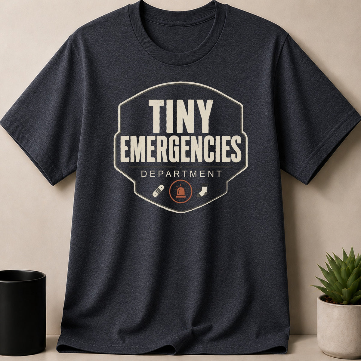 Dark Heather t-shirt — T-shirt with "Tiny Emergencies Department" text and emergency icons.