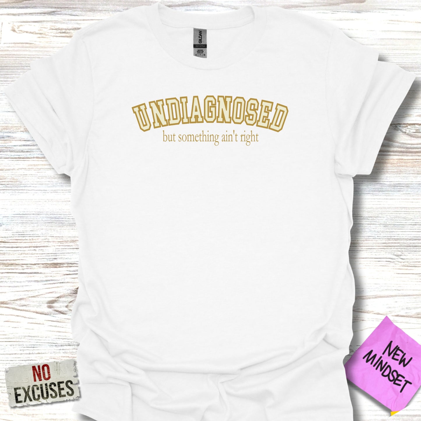White t-shirt with "UNDIAGNOSED but something ain't right" text and "NEW MINDSET" sticker.