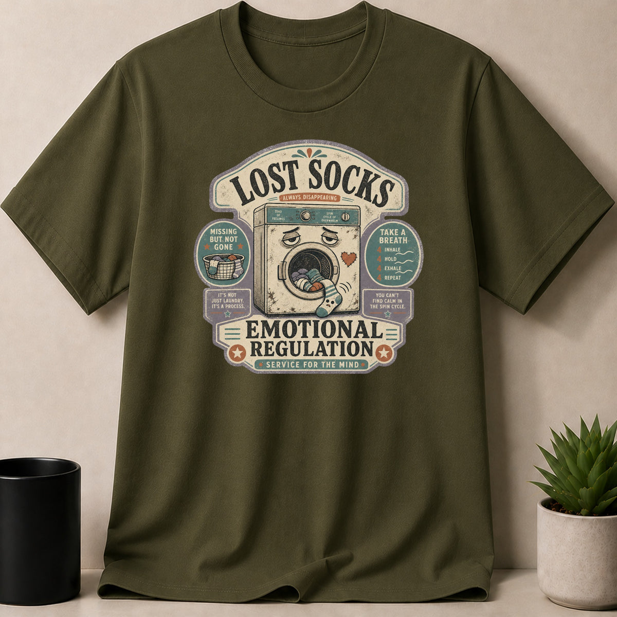 Green t-shirt with "Lost Socks Emotional Regulation" graphic and sad washing machine.