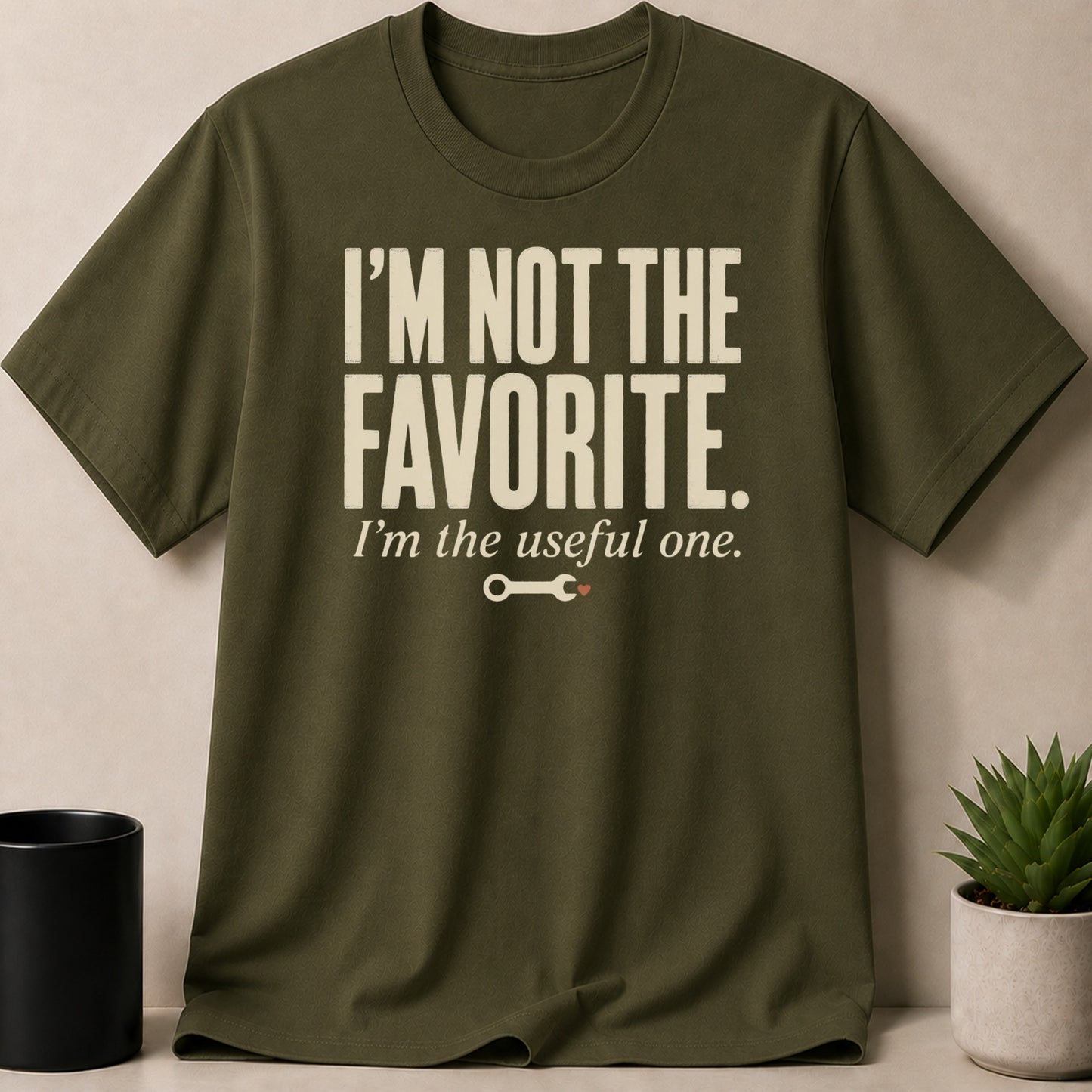 Olive green t-shirt with text "I'M NOT THE FAVORITE. I'm the useful one."