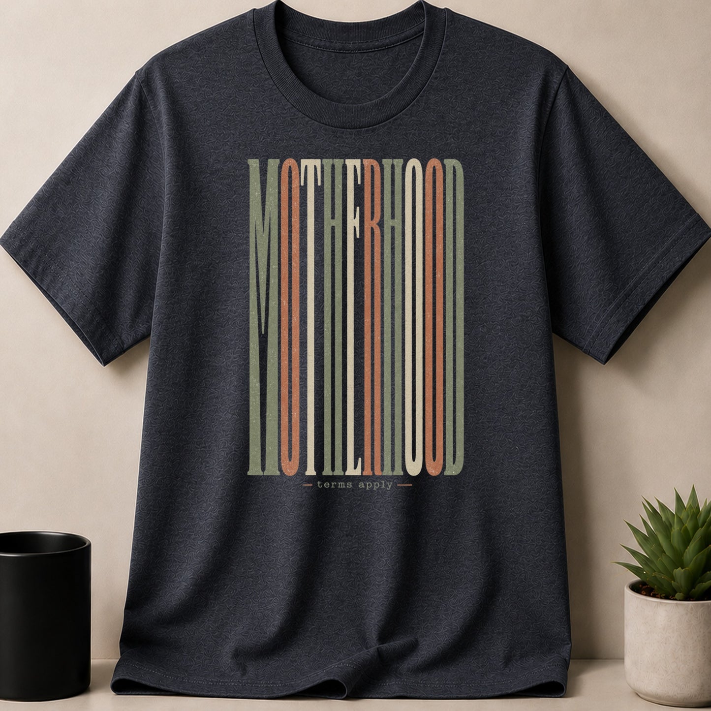 Dark grey t-shirt with vertical "MOTHERHOOD" text and "terms apply"