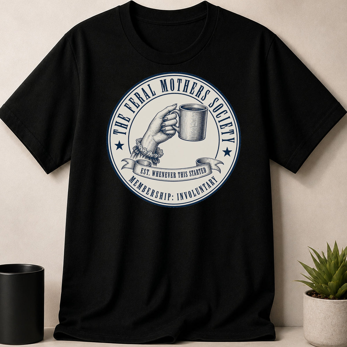 Black t-shirt with a circular graphic featuring a hand holding a mug and text.