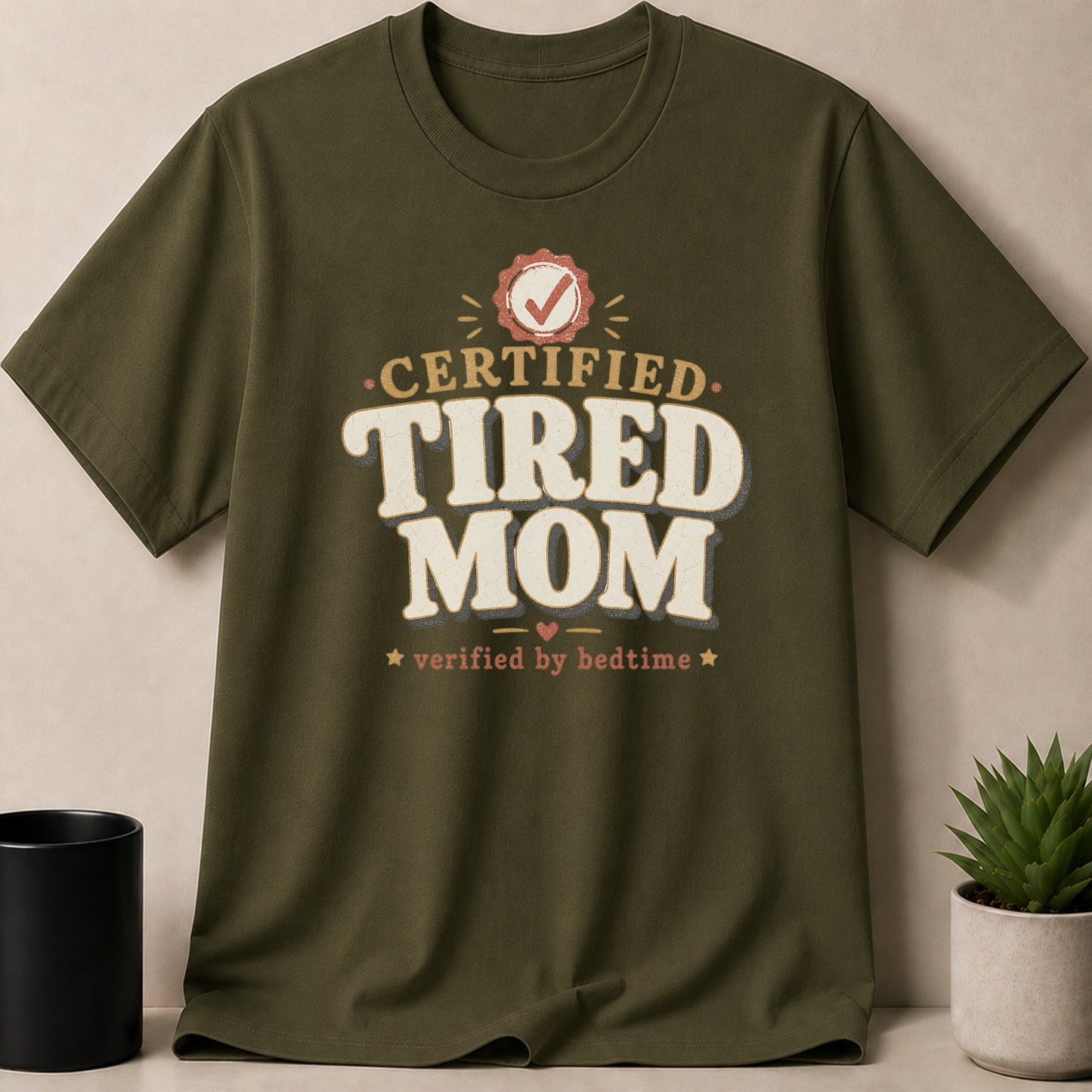 Olive green t-shirt with "CERTIFIED TIRED MOM" verified by bedtime graphic.