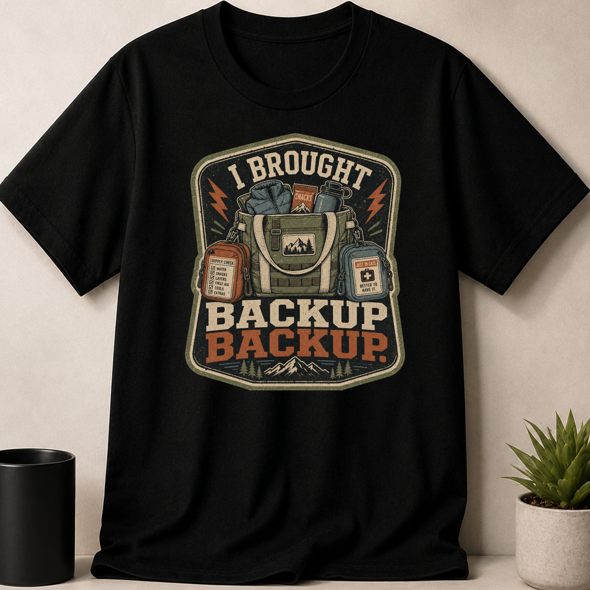 Black t-shirt with "I Brought Backup Backup" text and camping gear graphic.