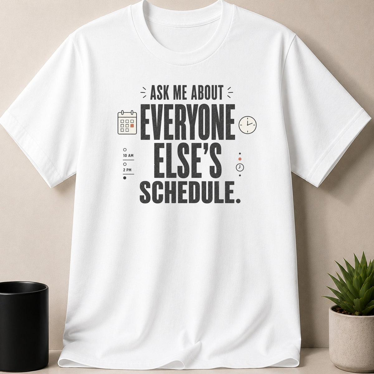 White t-shirt with sarcastic text "ask me about everyone else's schedule."