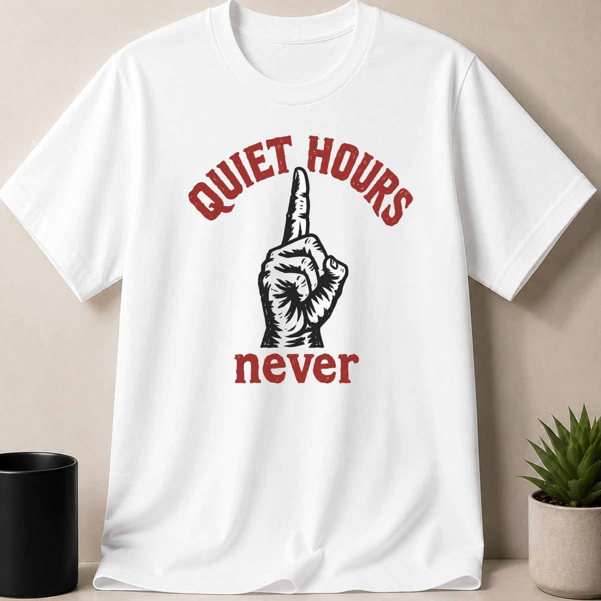 White t-shirt with red text "QUIET HOURS never" and a hand with pointer finger raised.