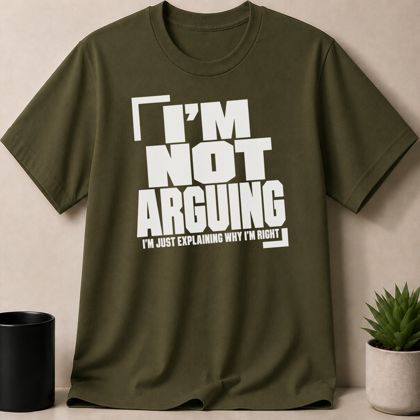 Olive green t-shirt with white text "I'M NOT ARGUING I'M JUST EXPLAINING WHY I'M RIGHT".