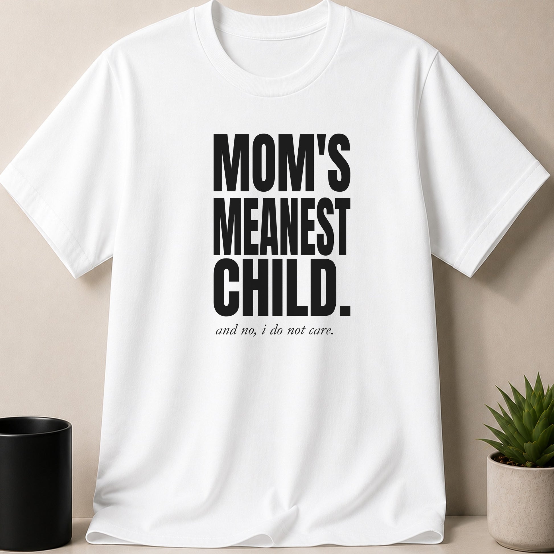 White t-shirt with black text: MOM'S MEANEST CHILD. and no, i do not care.