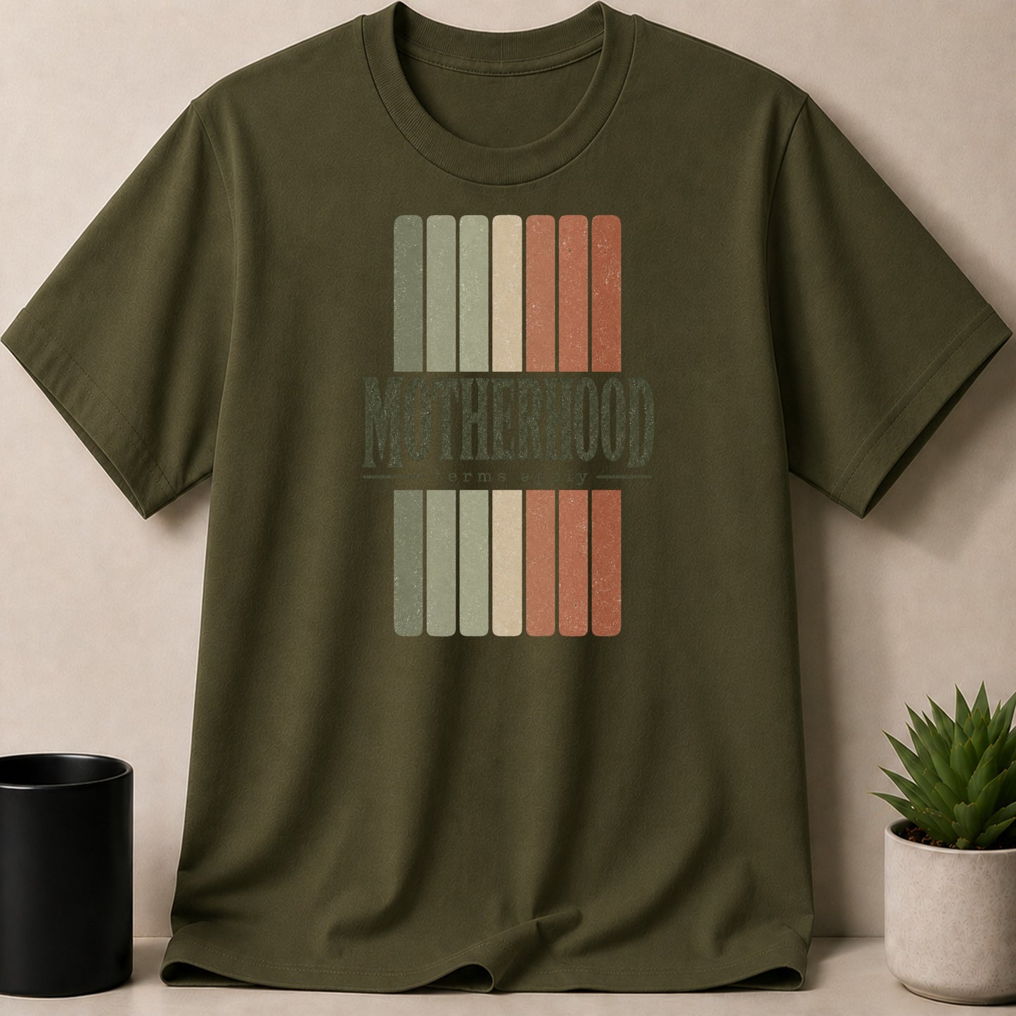 Green t-shirt with "Motherhood" text and distressed vertical stripes design.