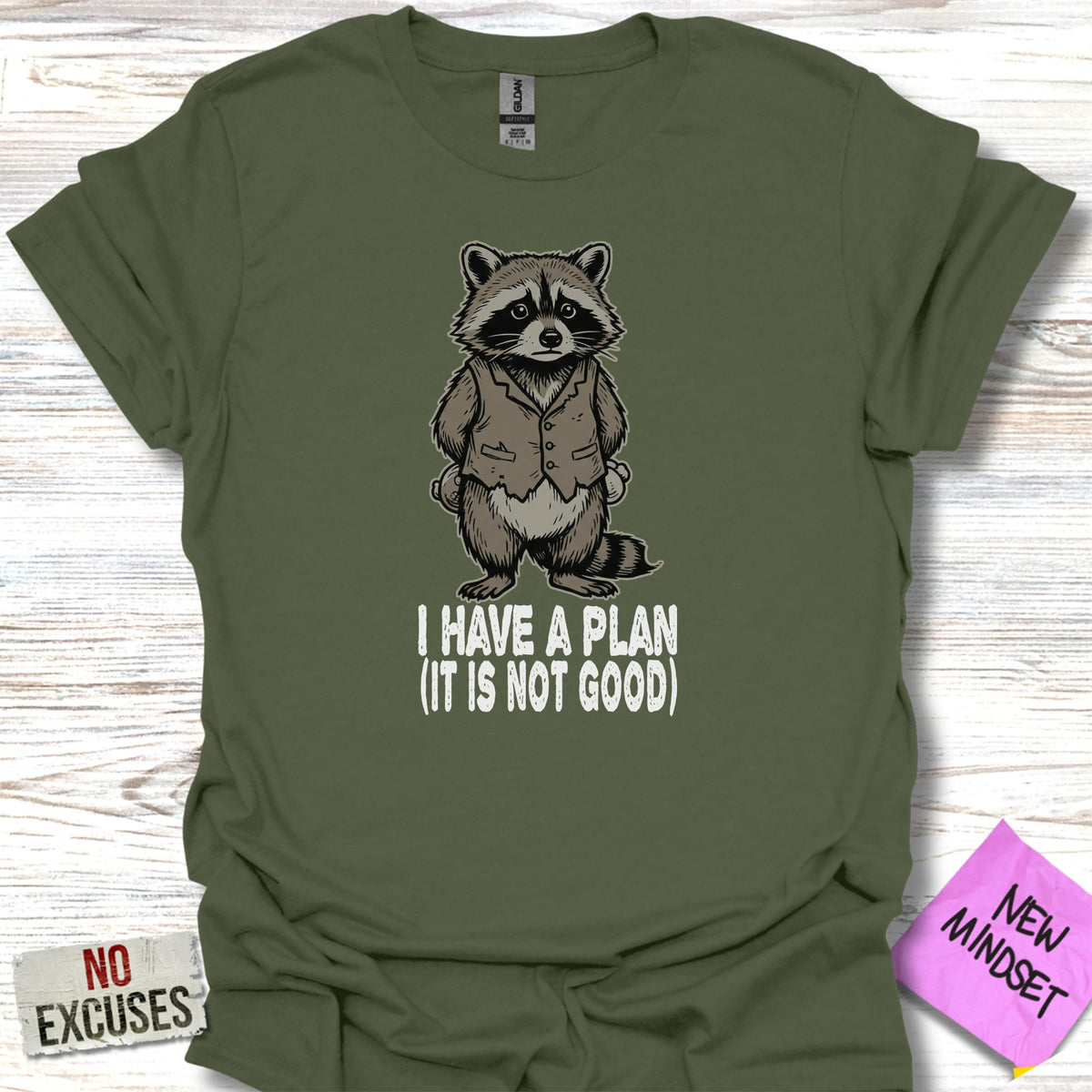 Olive green t-shirt with a raccoon in a suit and text "I HAVE A PLAN (IT IS NOT GOOD)".