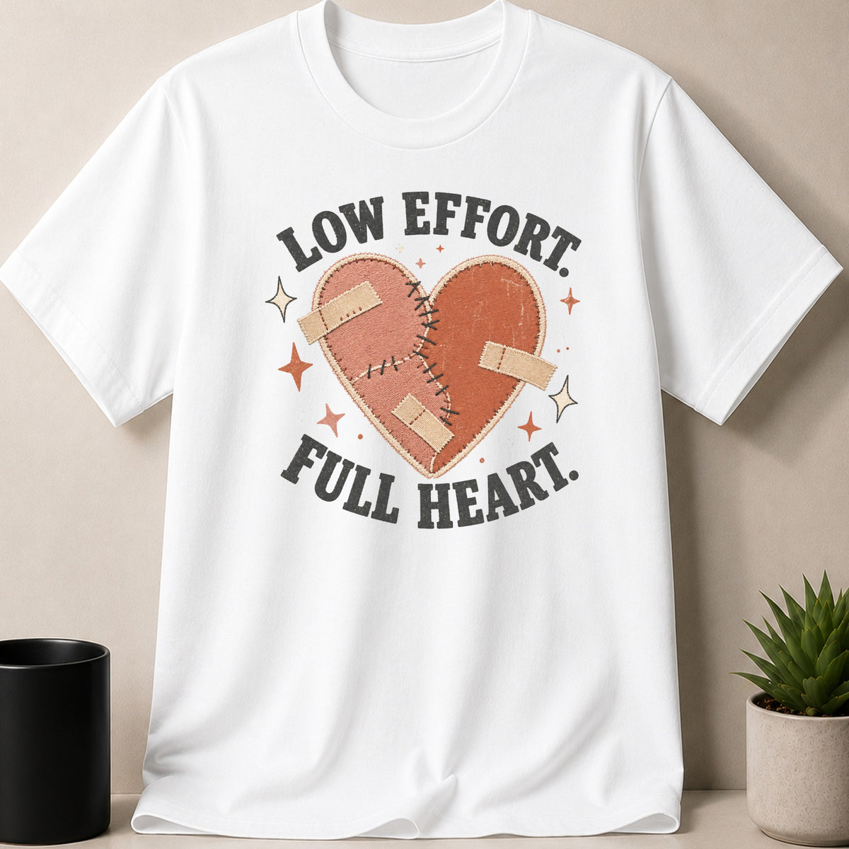 White t-shirt with heart graphic and text "Low Effort. Full Heart."