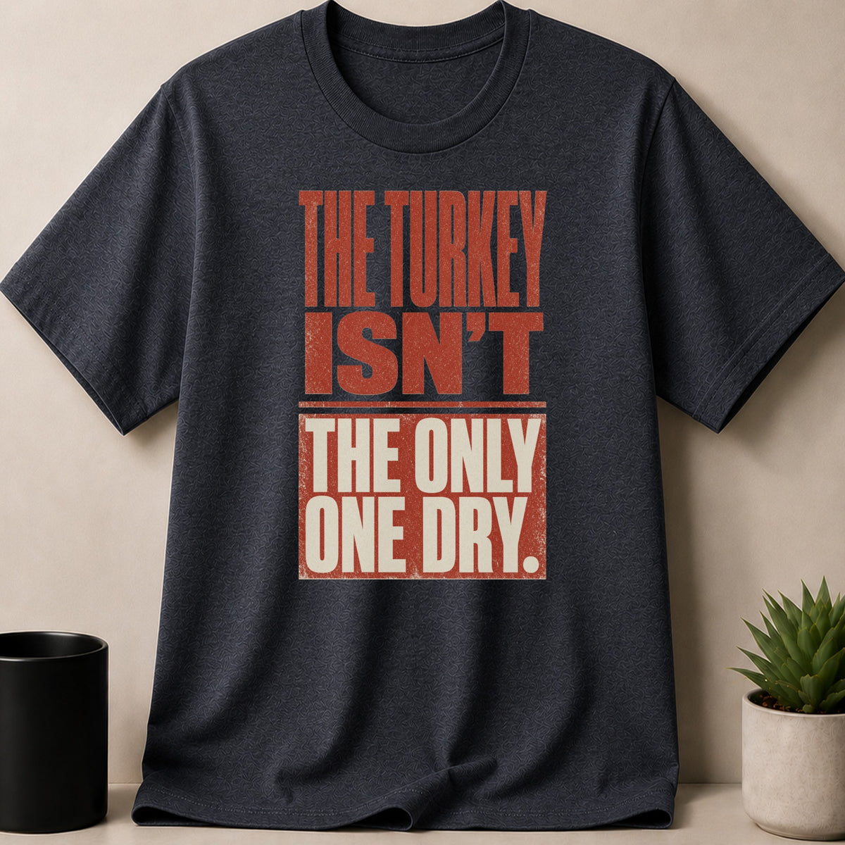 Dark grey t-shirt with red and cream text reading "The turkey isn't the only one dry."