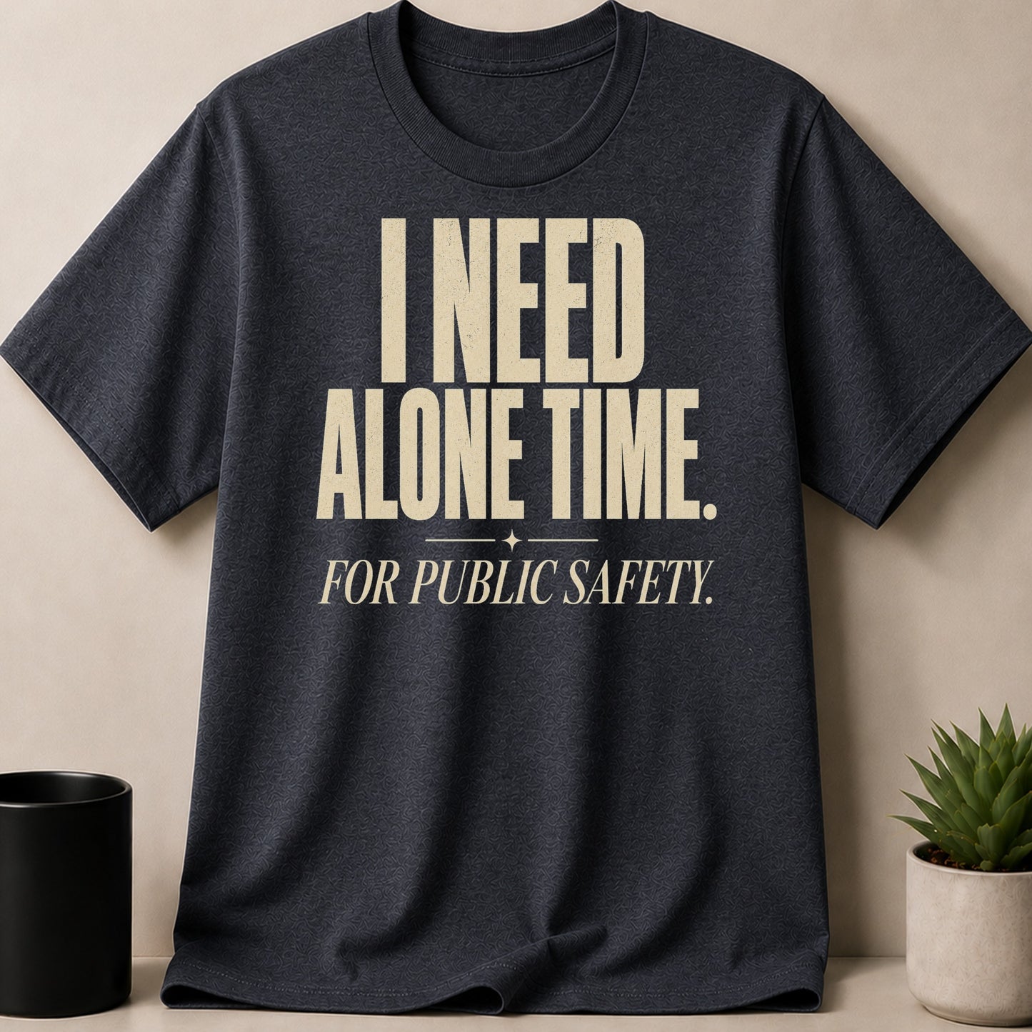 Dark grey t-shirt with cream text "I NEED ALONE TIME. FOR PUBLIC SAFETY."