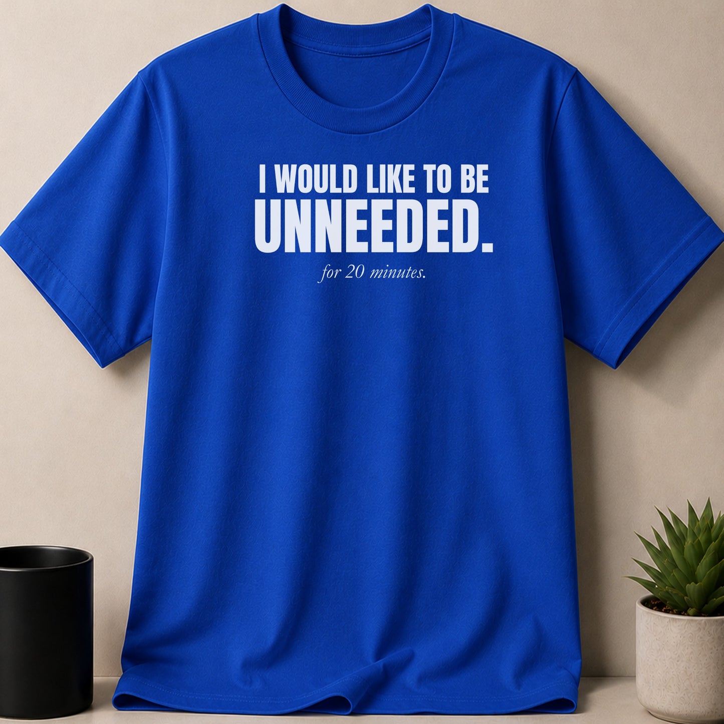 Royal blue t-shirt with white text saying "I WOULD LIKE TO BE UNNEEDED. for 20 minutes."