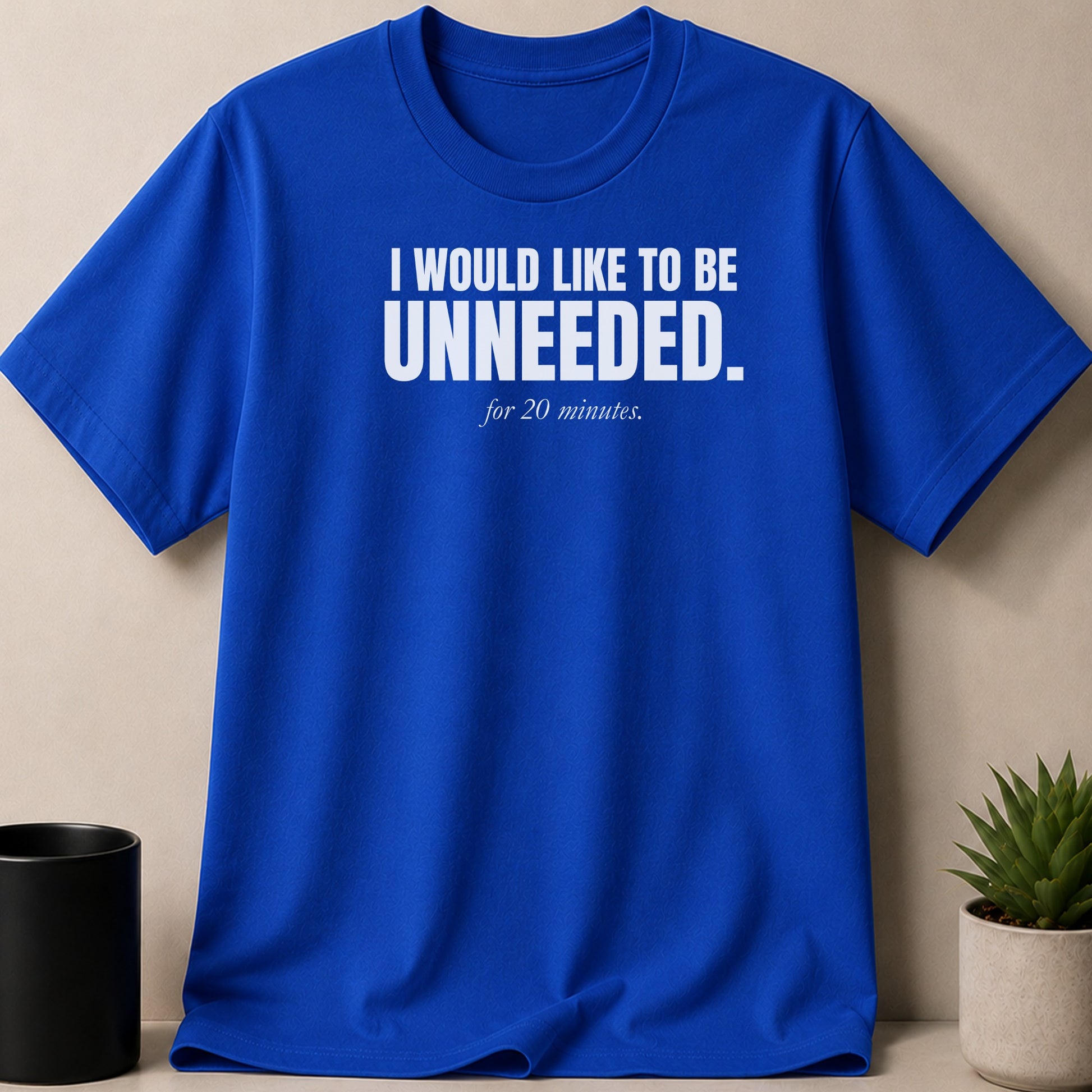 Royal blue t-shirt with white text saying "I WOULD LIKE TO BE UNNEEDED. for 20 minutes."