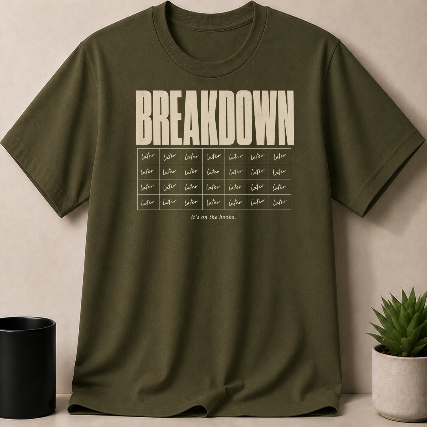 Olive green t-shirt with "BREAKDOWN" and "it's on the books." text.