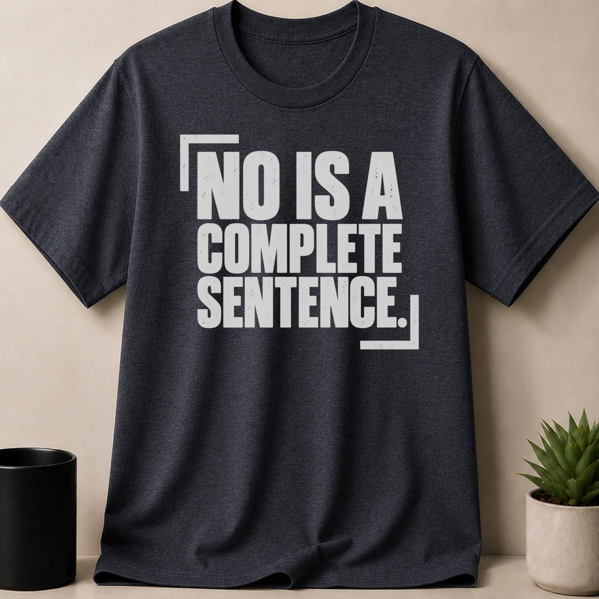 A dark charcoal crewneck t-shirt featuring the white distressed text NO IS A COMPLETE SENTENCE.