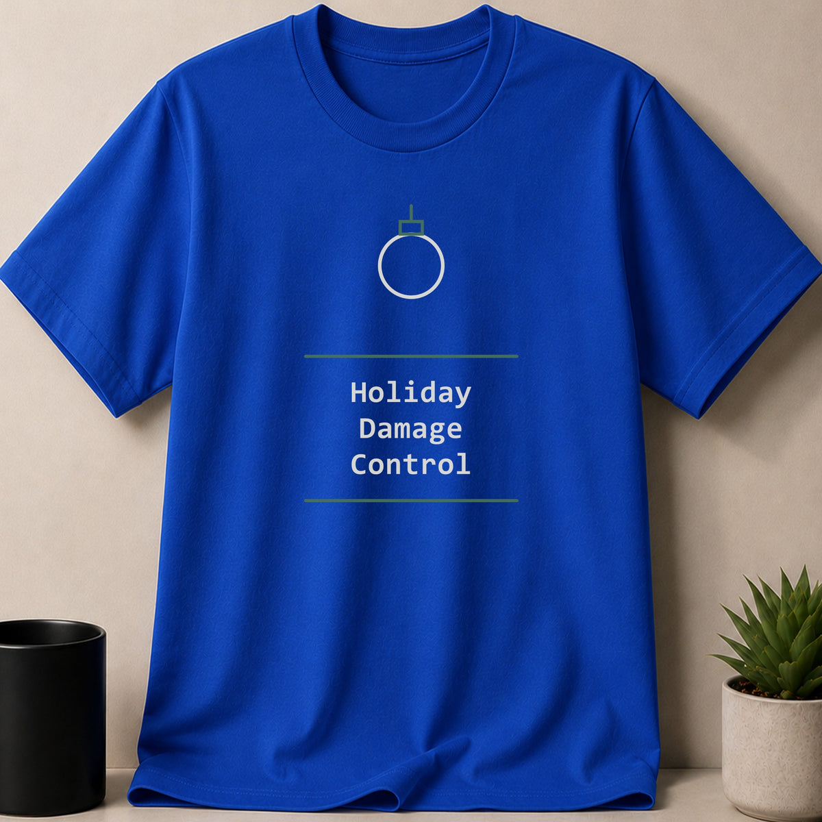 A royal blue crewneck t-shirt with a white holiday ornament graphic and the text Holiday Damage Control.