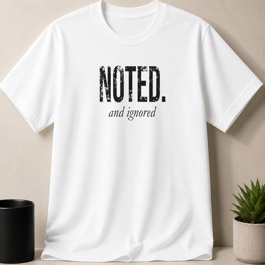 White t-shirt with "NOTED. and ignored" text in black distressed font.