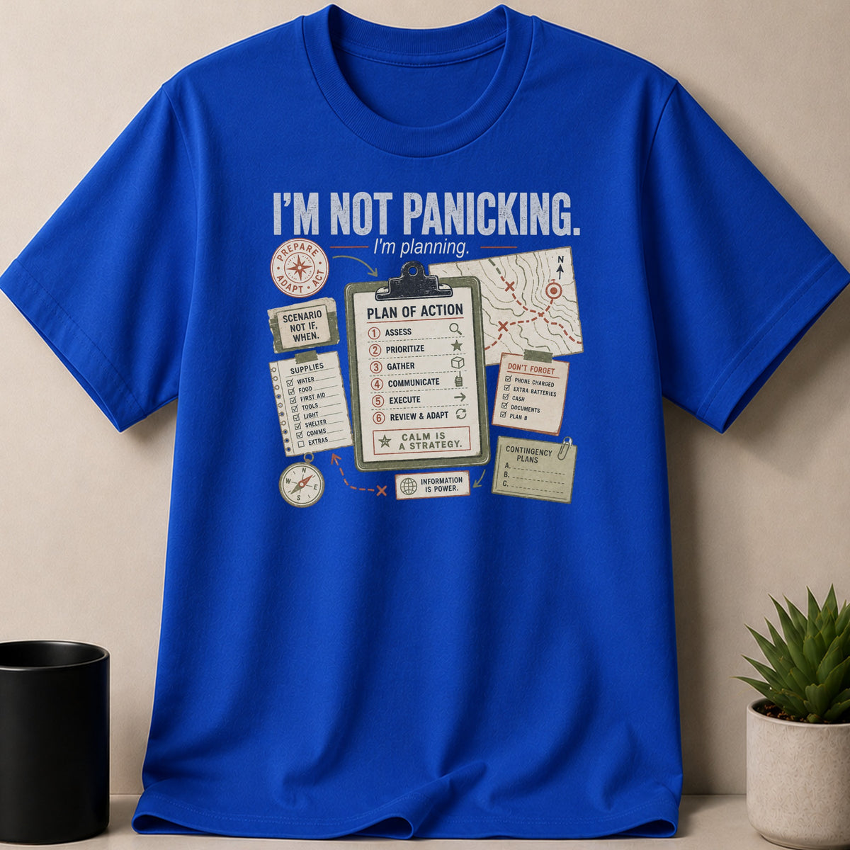 Blue t-shirt with a graphic displaying the text "I'M NOT PANICKING. I'm planning." and a plan of action.