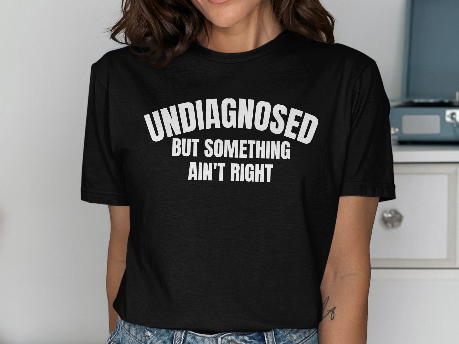 Black t-shirt with text "UNDIAGNOSED BUT SOMETHING AIN'T RIGHT"