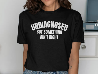 Black t-shirt with text "UNDIAGNOSED BUT SOMETHING AIN'T RIGHT"