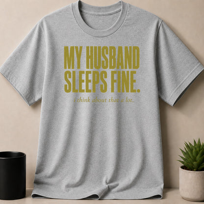 Grey t-shirt with gold text reading "MY HUSBAND SLEEPS FINE. i think about that a lot."